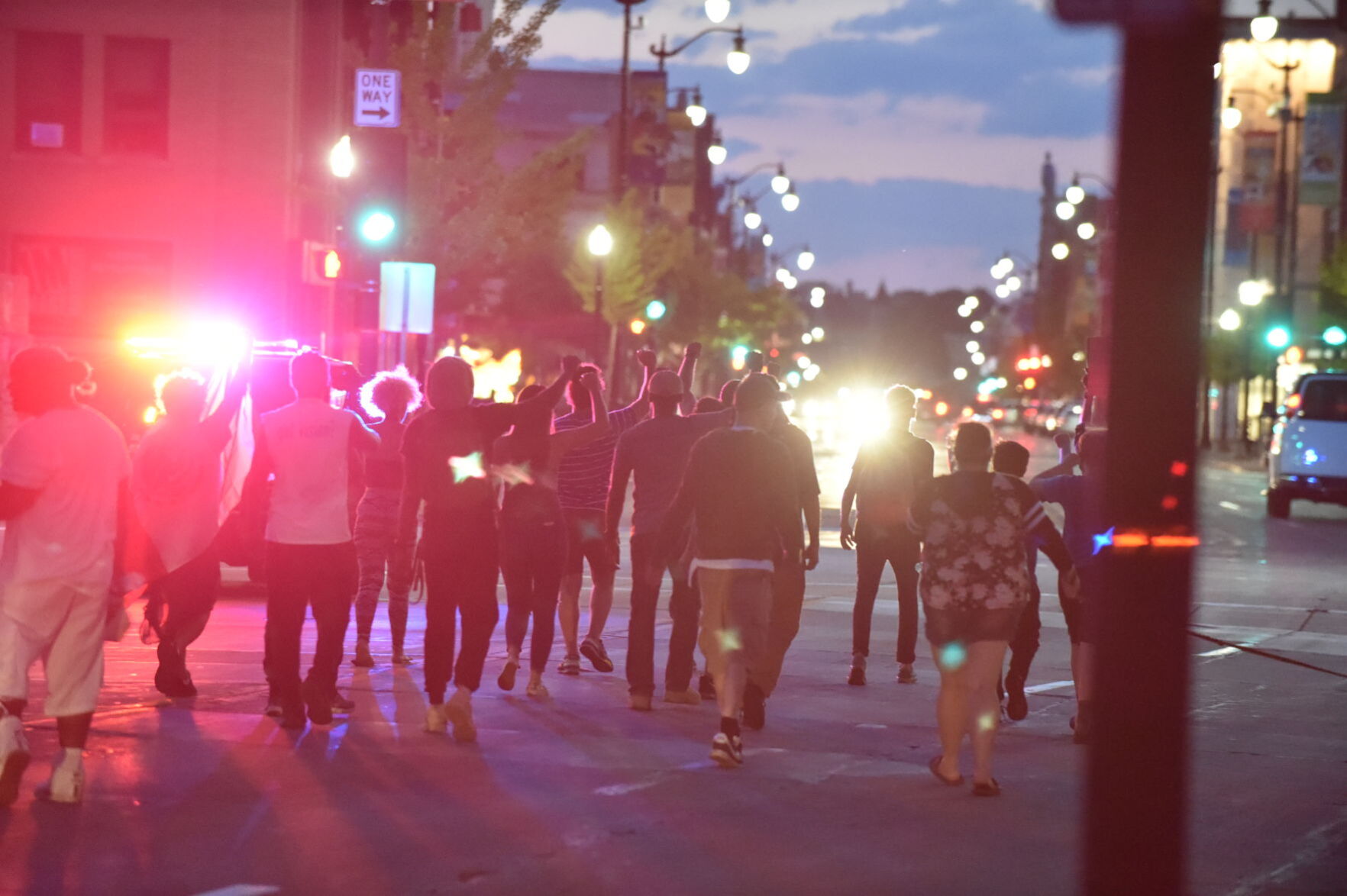 Marching down Main Street while squad car lights flash